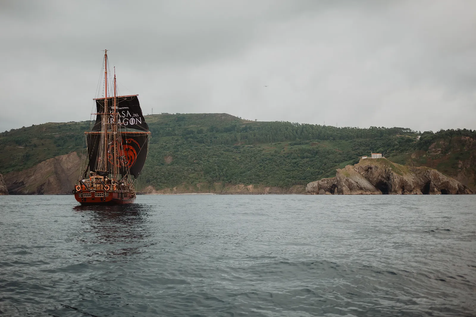 Barco con velas negras de La casa del dragón frente a la costa